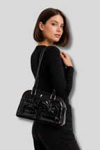 Femme portant un sac épaule noir brillant avec nœuds sur l’épaule – AlluTurne