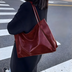 Sac cabas brillant rouge bordeaux porté par une femme, allure moderne et intemporelle