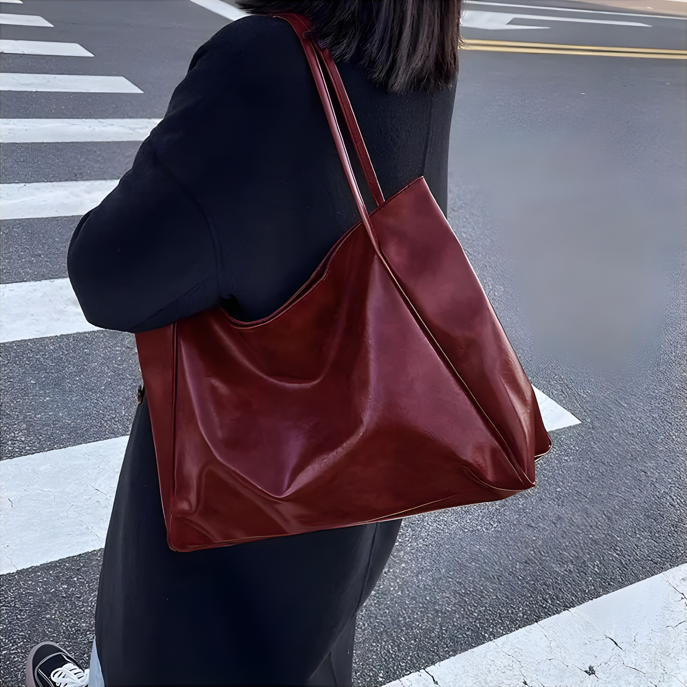 Sac cabas brillant rouge bordeaux porté par une femme, allure moderne et intemporelle