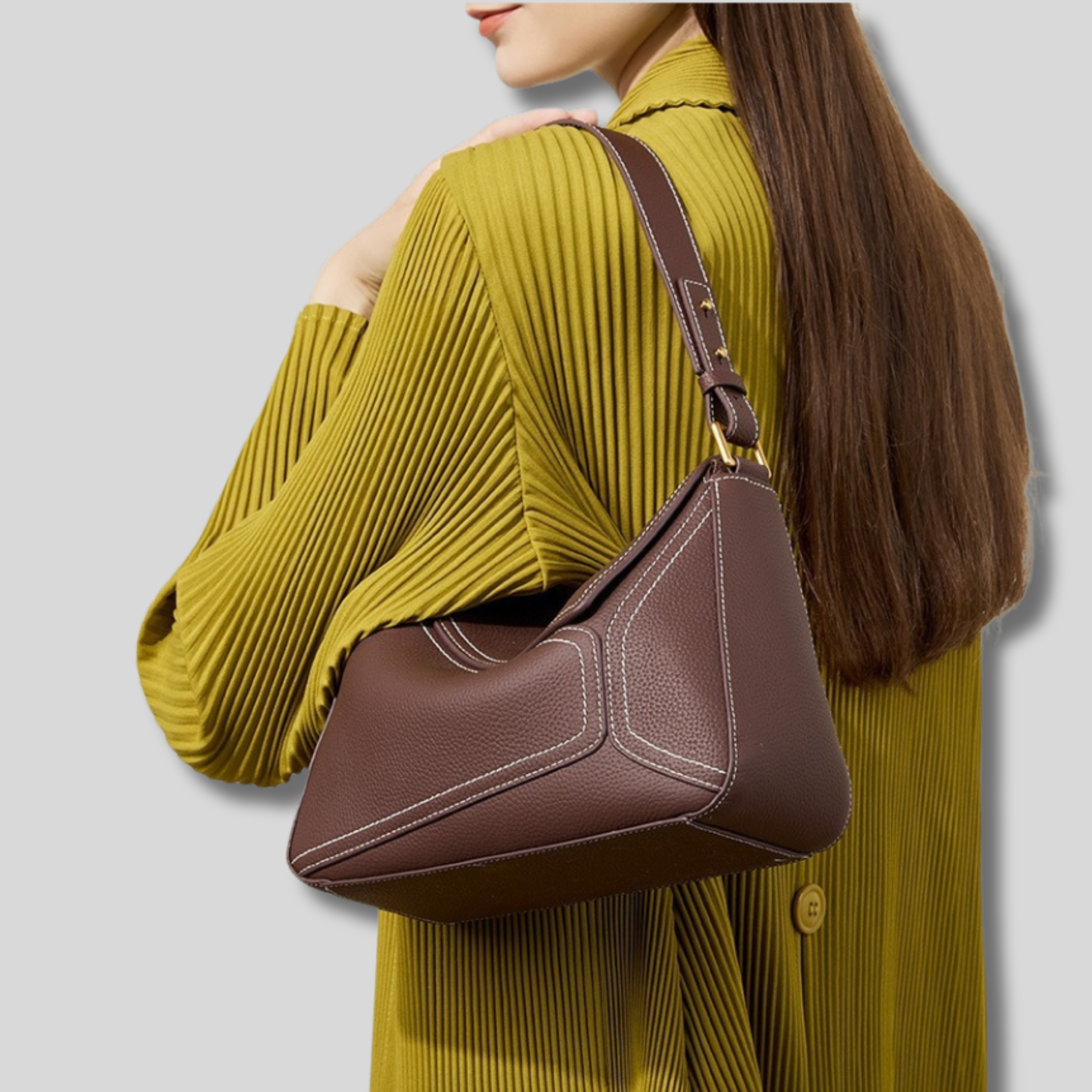 Sac bandoulière en cuir marron porté à l’épaule par une femme, vue de dos