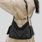 Sac Bandoulière Orélyne noir porté à l’épaule avec tenue élégante beige pour un style chic au quotidien.