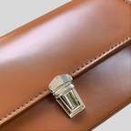 Détail du fermoir doré du sac baguette Éloria en cuir PU marron clair, finition élégante et raffinée.