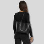 Femme portant sac cabas noir sur l’épaule vue de dos