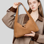 Femme portant le Sac Épaule Ambréa camel en cuir véritable effet daim au style urbain chic.
