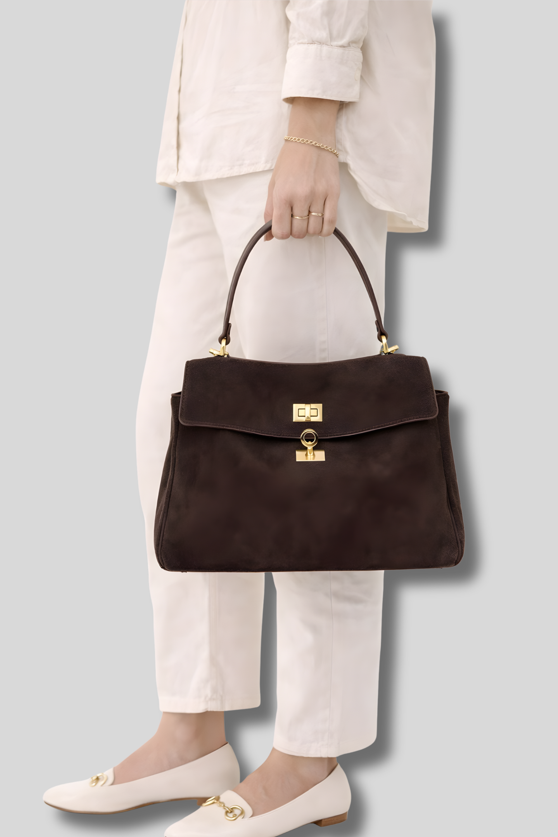 Femme tenant un sac bandoulière en suède marron élégant à la main