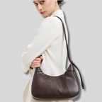 Femme portant le Sac Épaule Rovelle marron foncé en cuir véritable sur l’épaule
