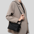 Sac Bandoulière Élysande noir en cuir véritable porté avec un blazer élégant