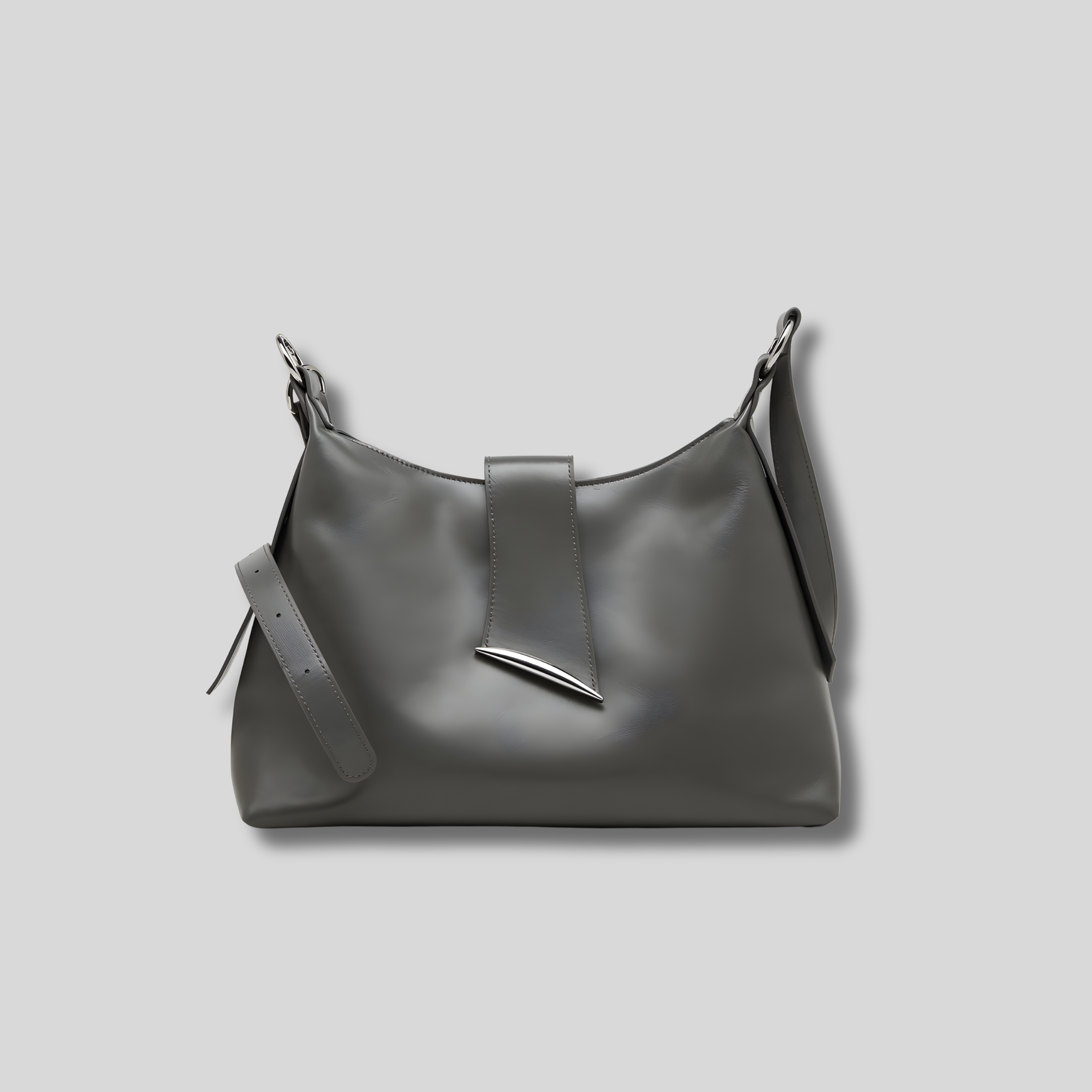 Sac bandoulière en cuir gris taupe, silhouette épurée et forme douce, anse ajustable avec finitions argentées.