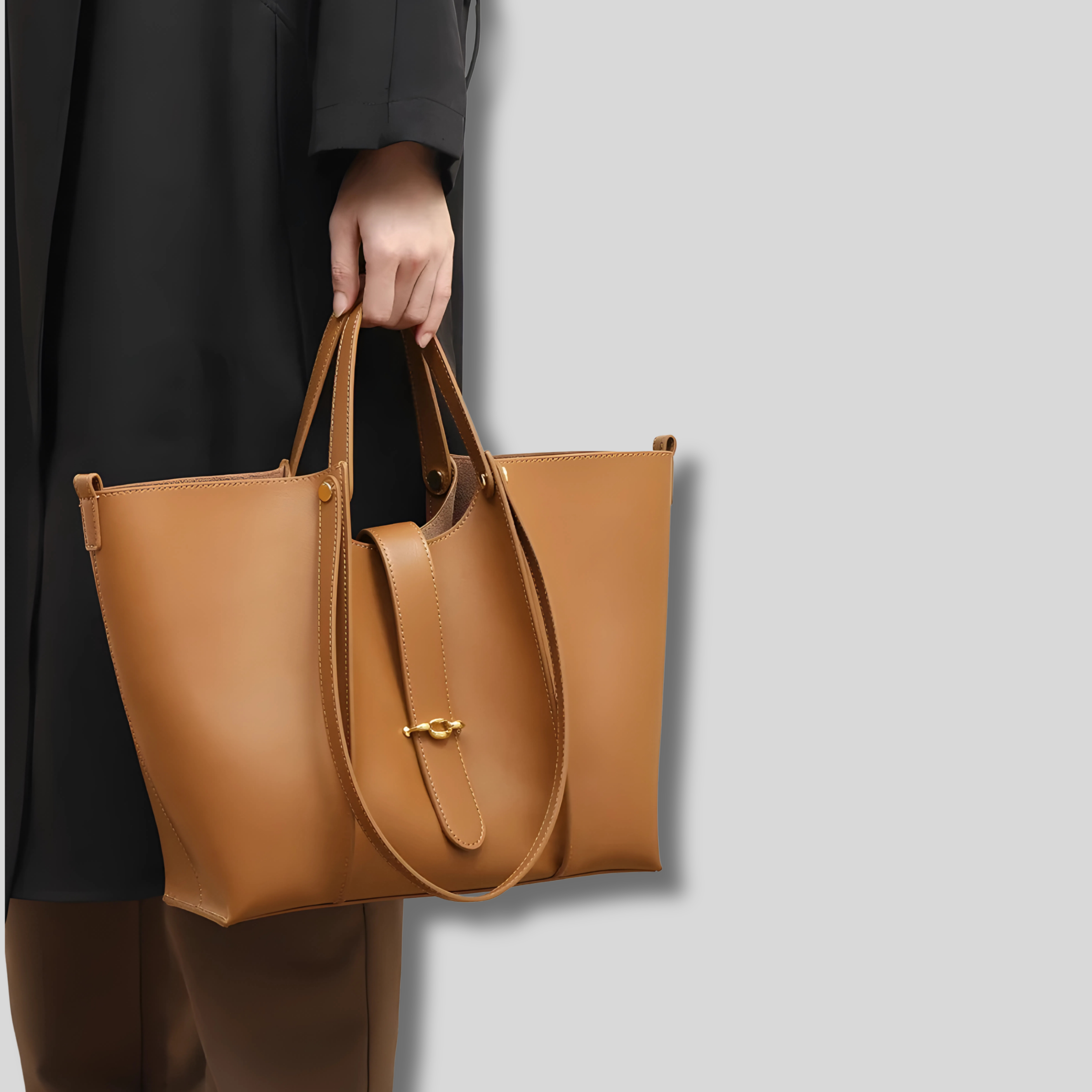 Sac à main femme marron porté à la main, design minimaliste avec détails dorés