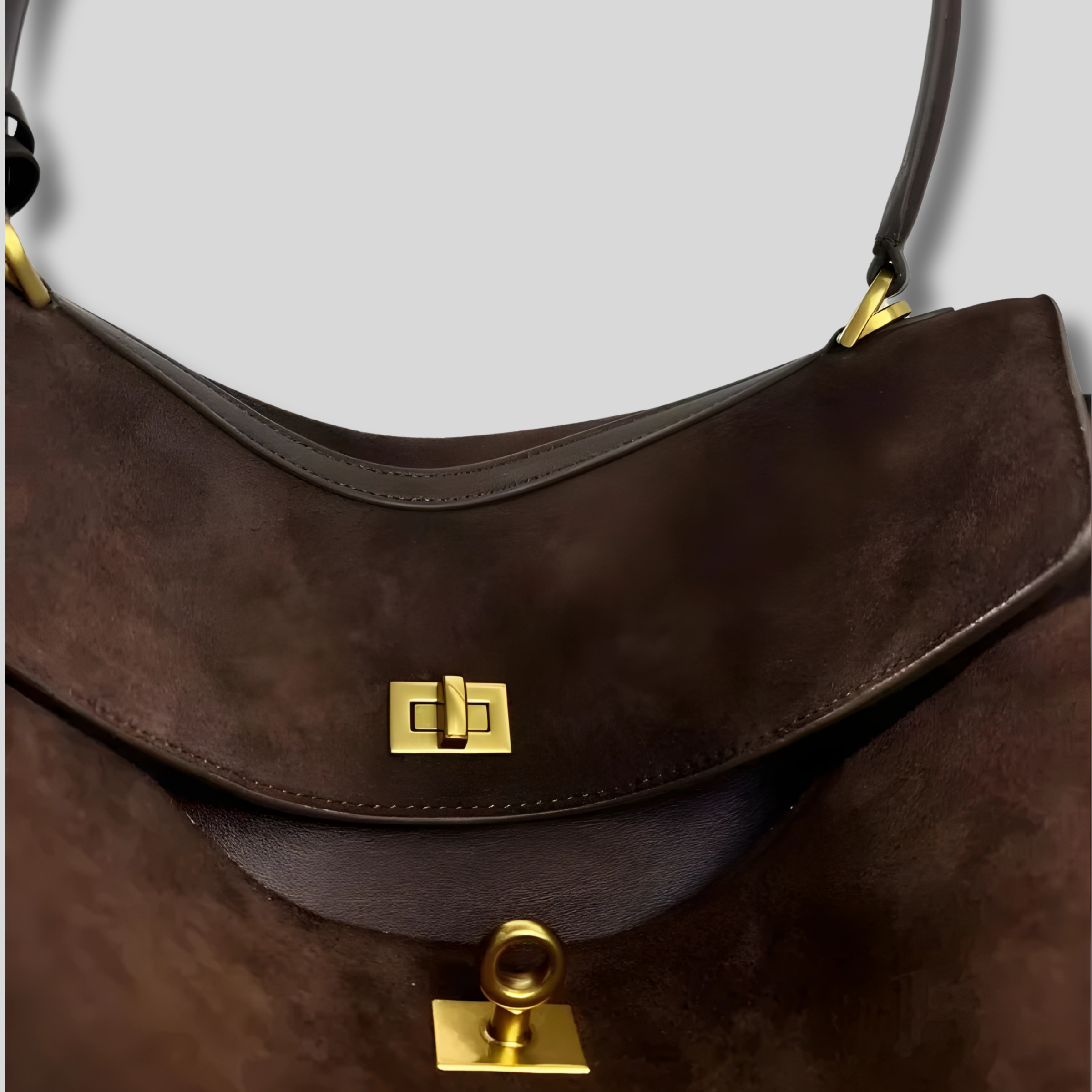 Détail du fermoir doré sur sac bandoulière en suède marron premium