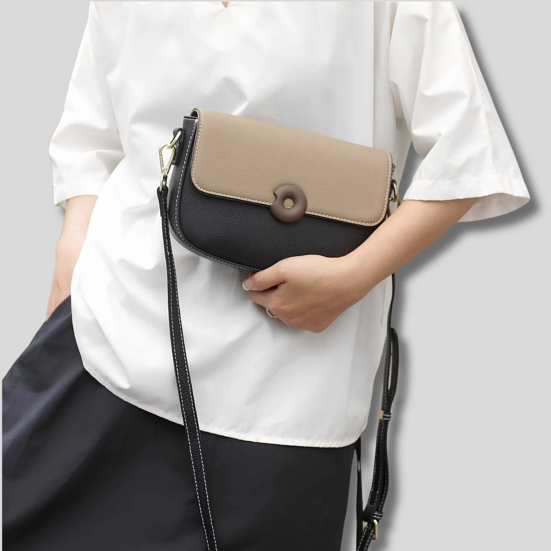 Sac bandoulière en cuir véritable porté en bandoulière par un mannequin