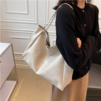 Sac cabas brillant beige porté par une femme, silhouette élégante et intemporelle