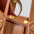Détail du sac à main marron avec finitions soignées et éléments métalliques dorés