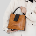 Femme portant un sac porté épaule camel vintage en cuir véritable au style élégant et moderne