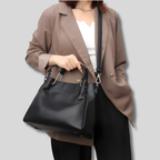 Sac seau Alméra noir porté à la main avec bandoulière ajustable