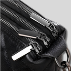 Détail des fermetures zippées métalliques du sac matelassé en cuir noir
