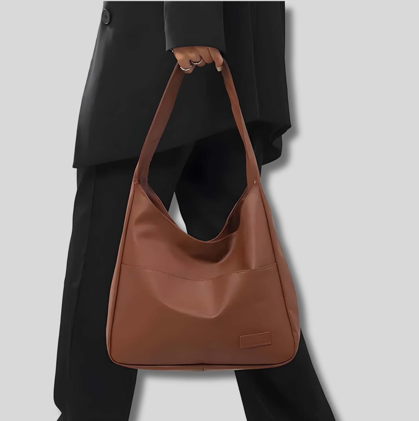 Sac épaule femme marron porté à la main – look urbain élégant