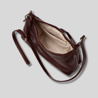 Intérieur sac bandoulière cuir marron avec fermeture zippée, doublure claire et poche intérieure organisée.