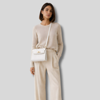 Femme portant sac bandoulière blanc élégant en bandoulière tenue beige chic