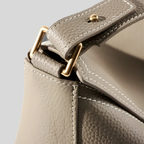 Détail de la fixation en métal doré sur sac en cuir texturé