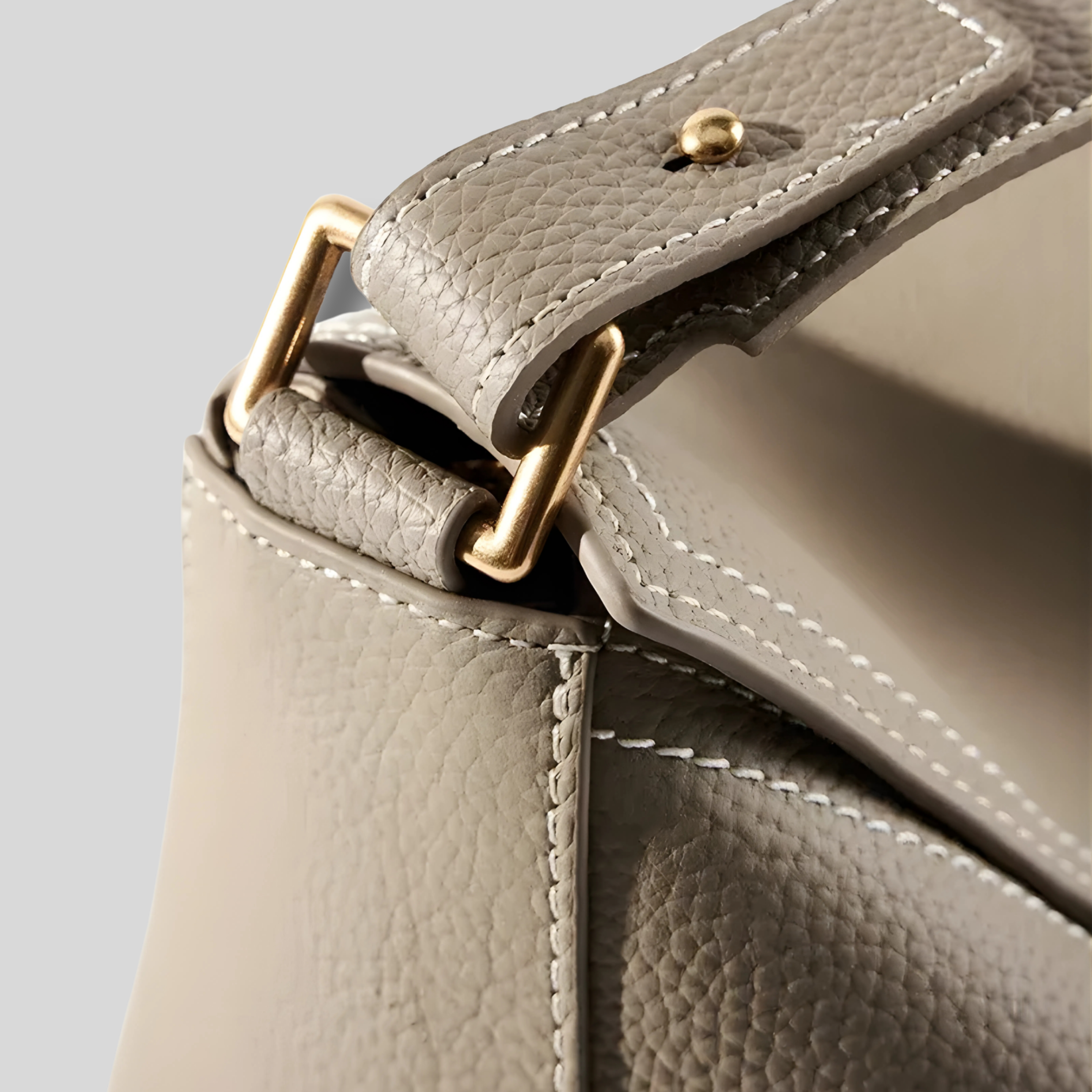 Détail de la fixation en métal doré sur sac en cuir texturé