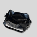 Intérieur du sac noir spacieux avec compartiments zippés et organisation pratique pour les essentiels