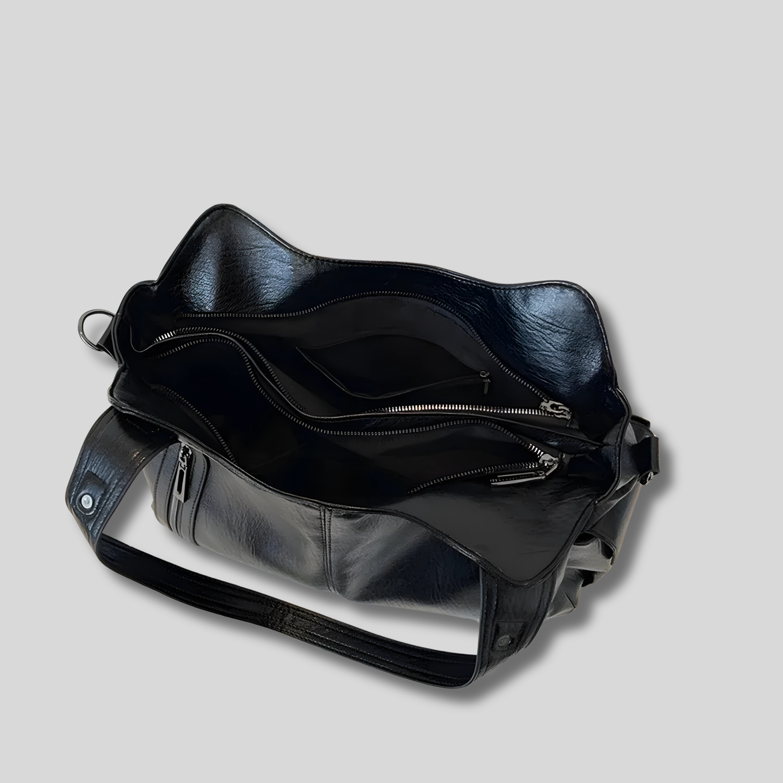 Intérieur du sac noir spacieux avec compartiments zippés et organisation pratique pour les essentiels