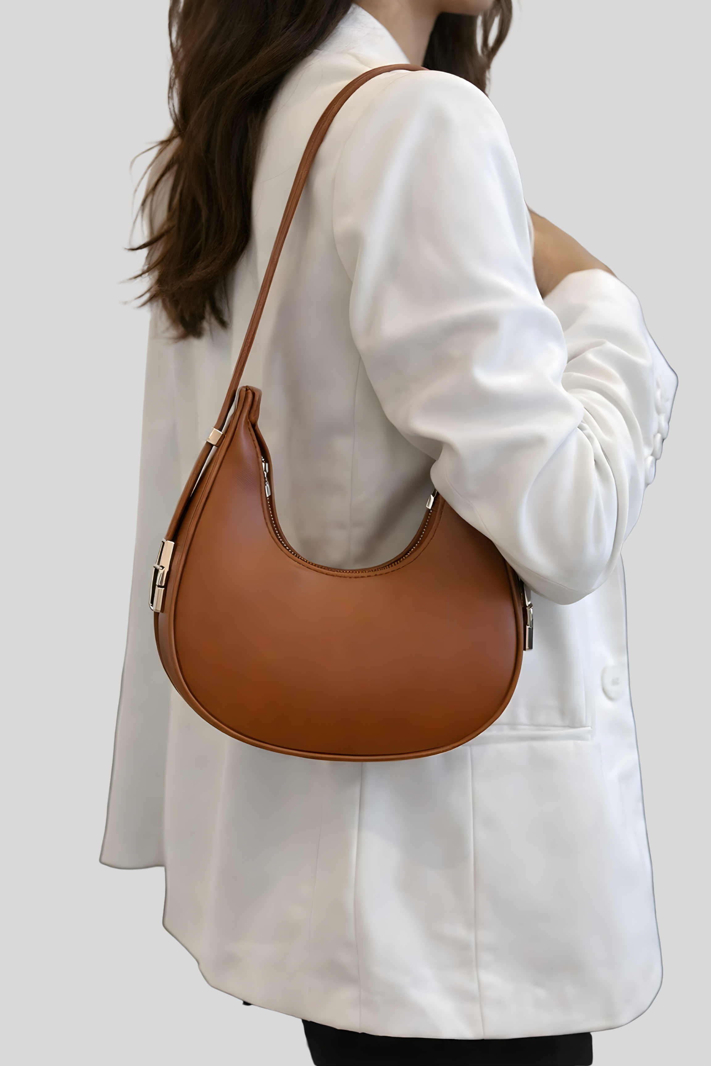 Sac demi-lune marron porté à l’épaule par une femme, style élégant et minimaliste, parfait pour un usage quotidien.
